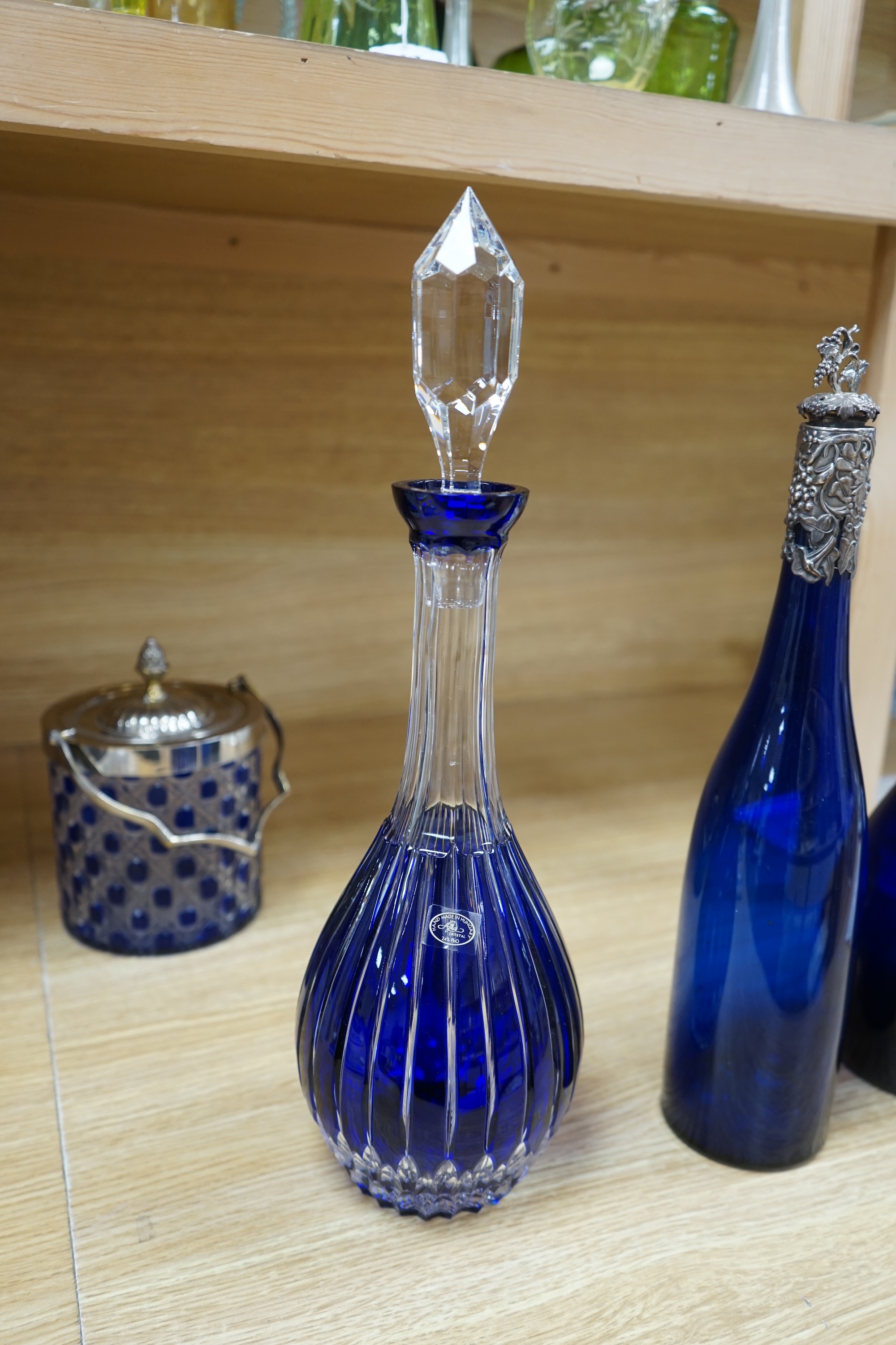 A collection of blue glassware comprising a late 18th century Bristol blue glass decanter and tear drop stopper, 30cm, a mid 19th century electroplate mounted blue glass decanter, a later Hungarian decanter and a similar